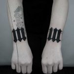 Matching black tattoos on both wrists
