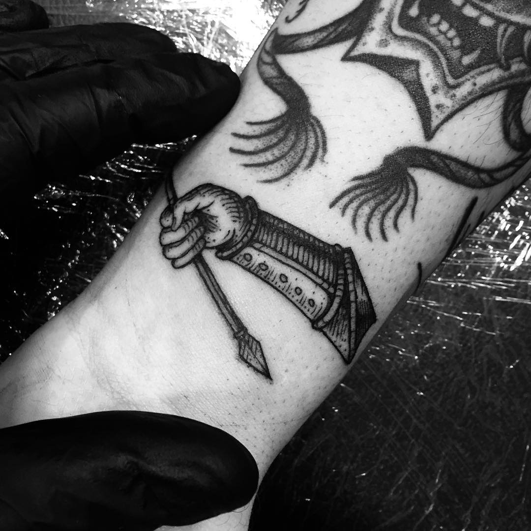 Medieval woodcut style arm and arrow tattoo