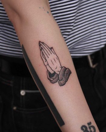 Praying hands tattoo on the forearm
