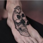 Skull and rose tattoo on the foot by Jonas Ribeiro