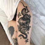 Skull and snake tattoo on the left thigh