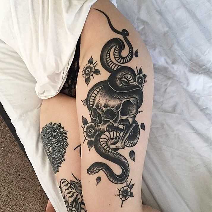 Skull and snake tattoo on the left thigh