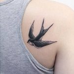 Swallow tattoo on the right shoulder blade