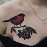 Tattoo of a little bullfinch on a rowan branch