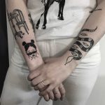Various black tattoos on forearms