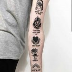 Various black tattoos on the left arm