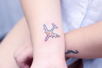 Watercolor airplane tattoo on the wrist