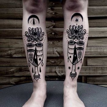 Abstract face and flower tattoos on shins