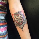 Black and red ornament tattoo on the forearm