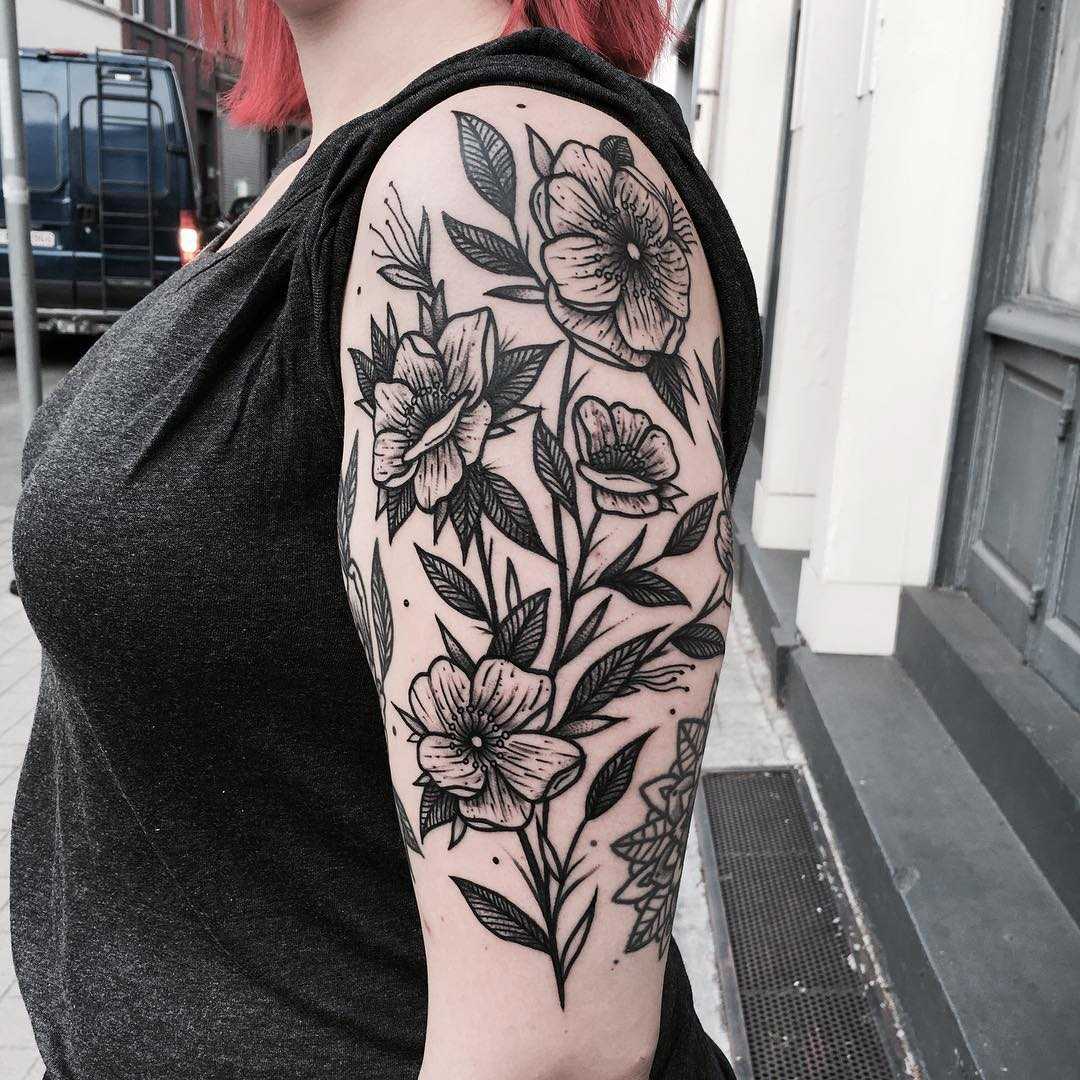 Black flowers tattooed on the arm