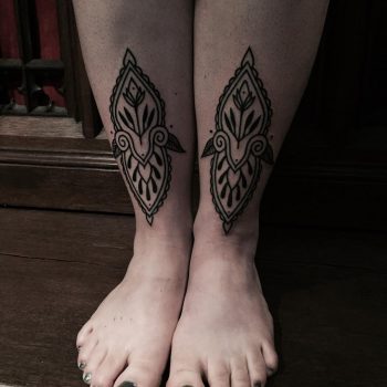 Black ornament tattoos on both shins