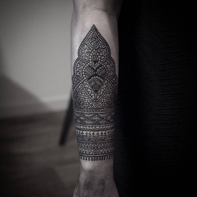 Black ornamental style forearm tattoo
