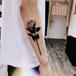 Black rose tattoo on the right forearm