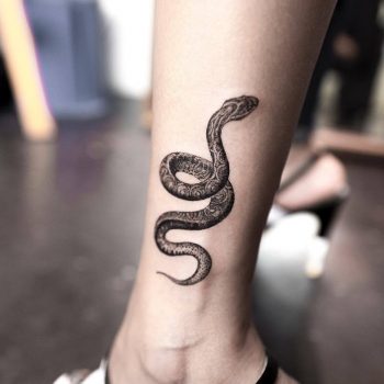 Black snake tattoo on the left calf