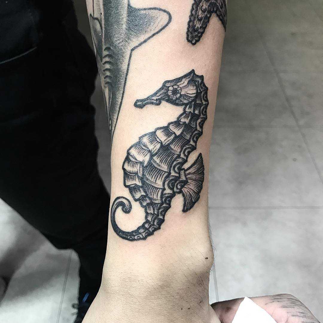 Blackwork seahorse tattoo on the forearm
