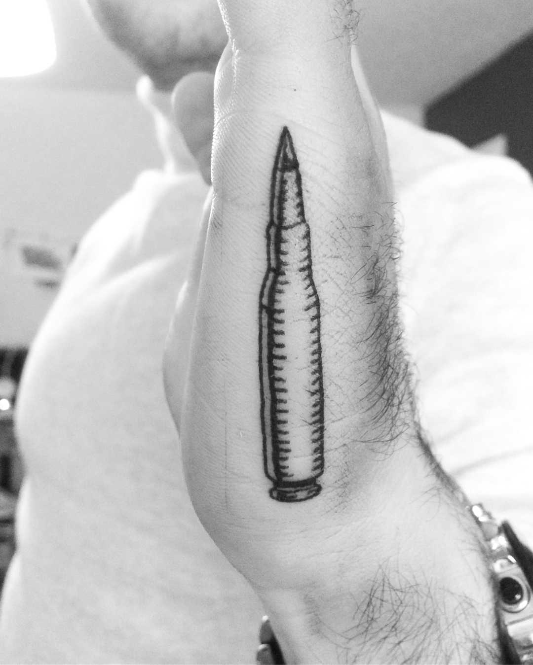 Bullet tattoo on the left hand 