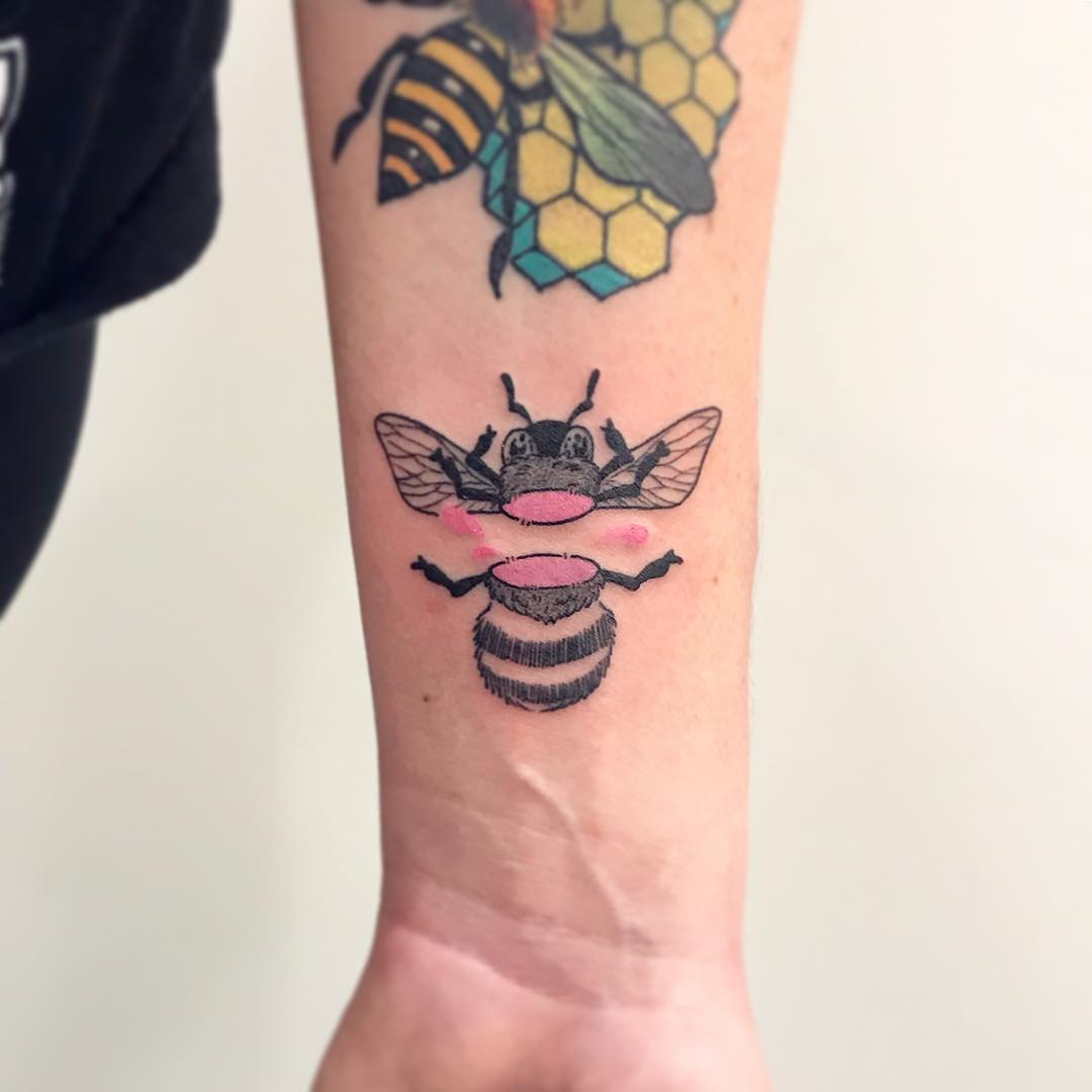 Colorful bees tattooed on the forearm