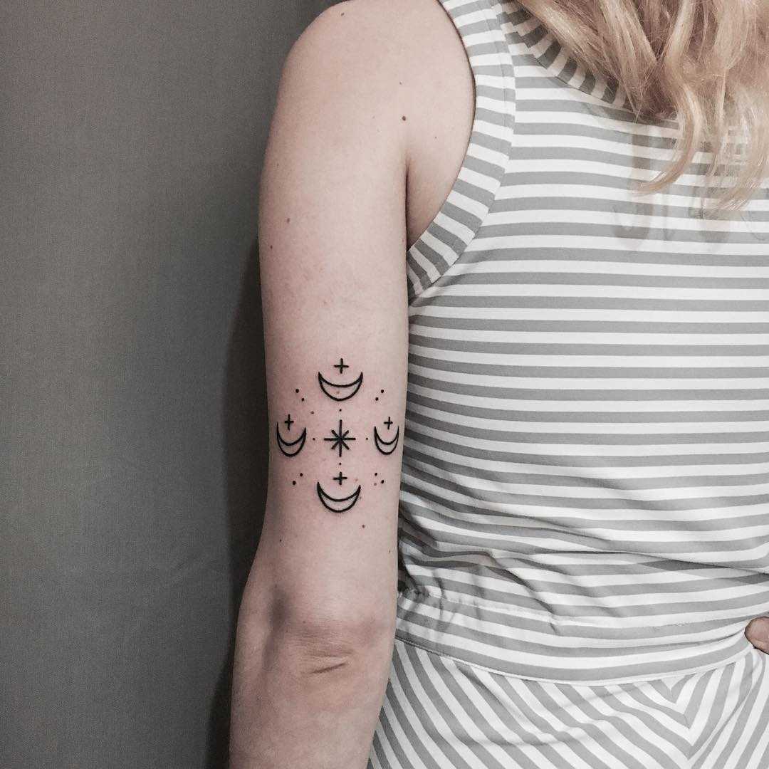 Four moons tattoo on the left arm
