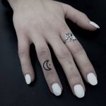 Hand-poked moon tattoo on the ring finger