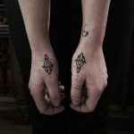 Matching black ornament tattoos on both hands