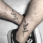 Matching branch tattoos on calves