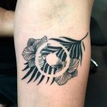 Negative space circle and flowers tattoo