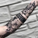 Negative space floral forearm tattoo