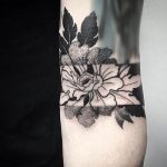 Negative space flower tattoo on the forearm