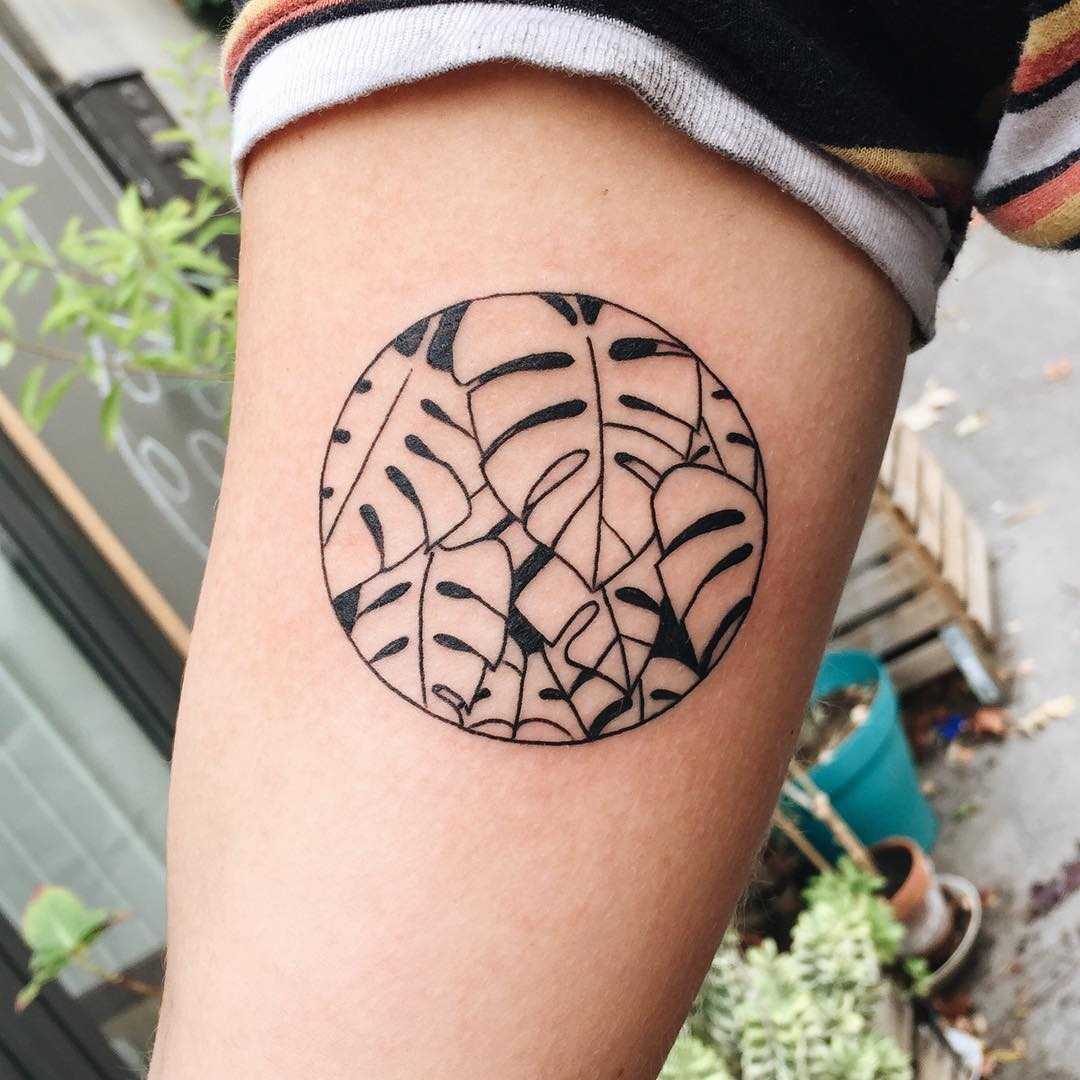 Negative space monstera circle tattoo
