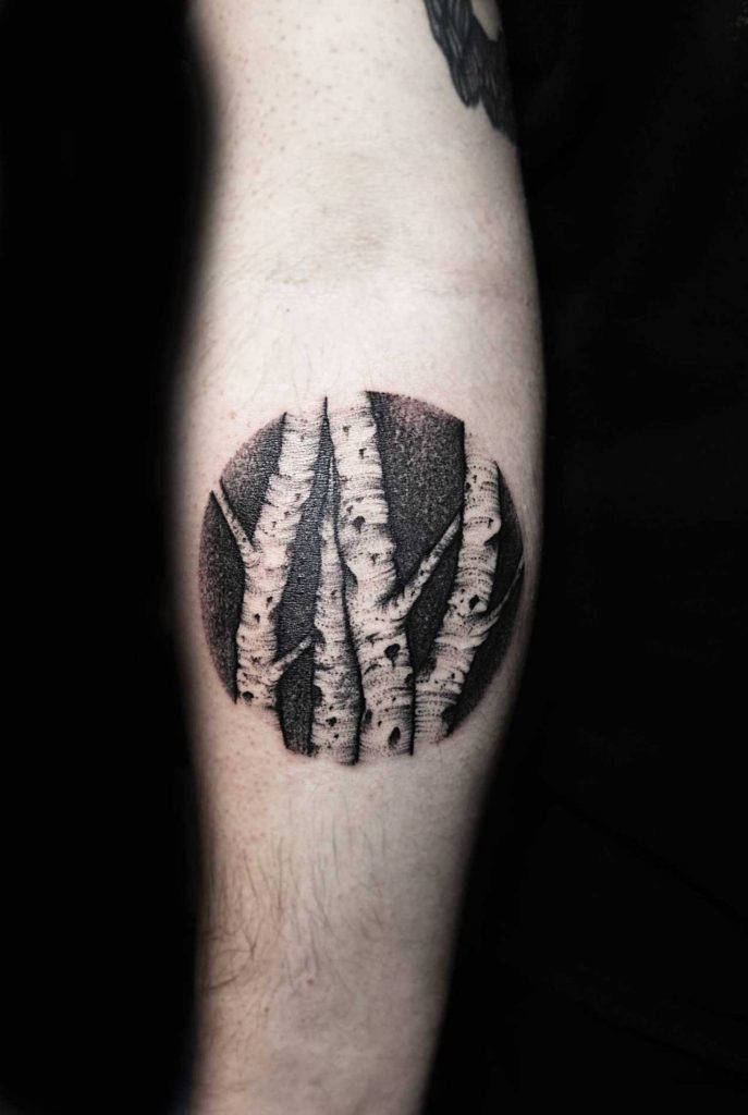 Negative space tree stems tattoo