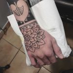 Outline flower tattoo on the right hand