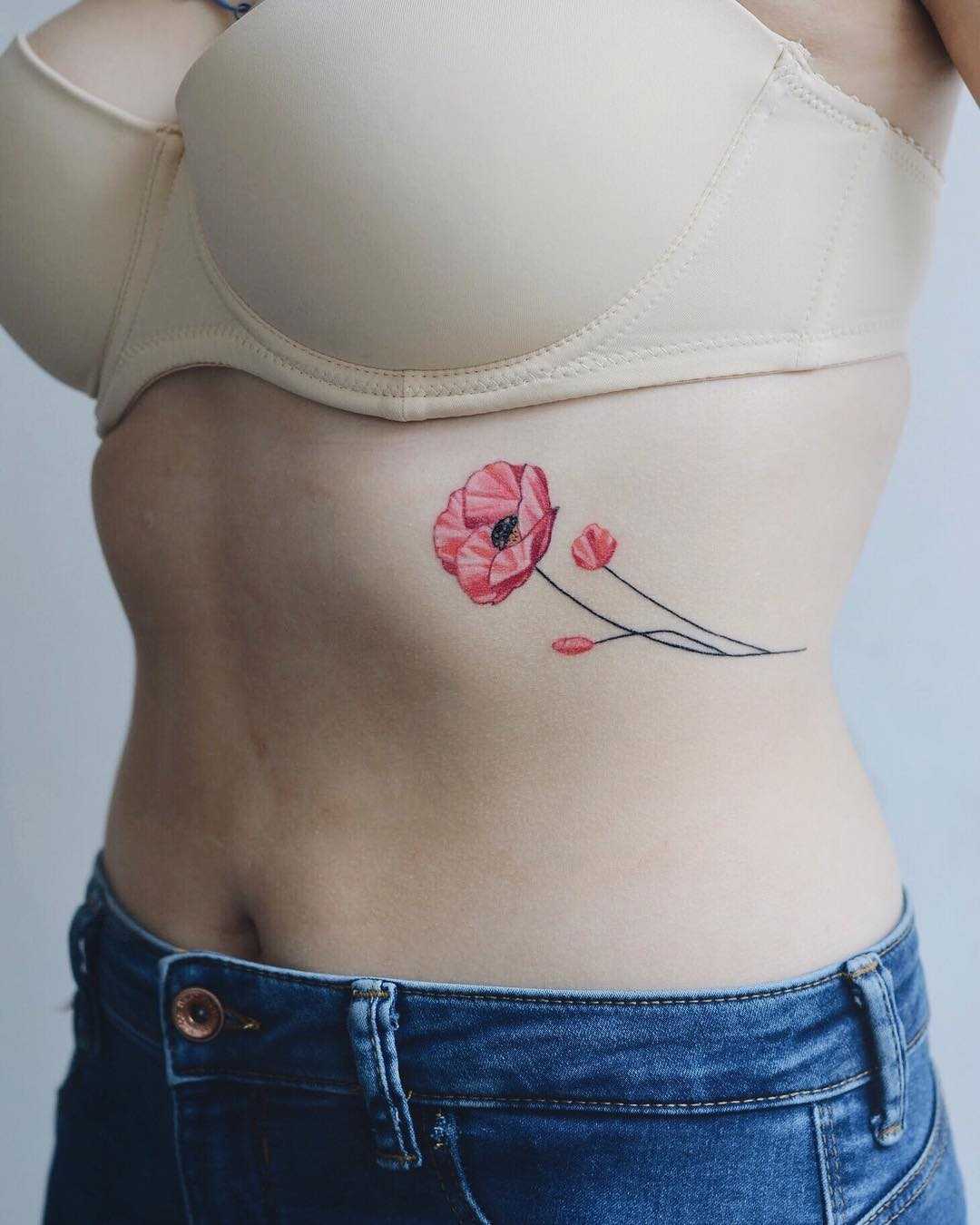 Pink flower tattoo on the rib cage
