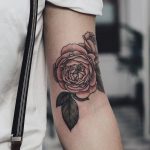Pink rose tattoo on the left arm