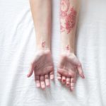 Red tattoos on both forearms