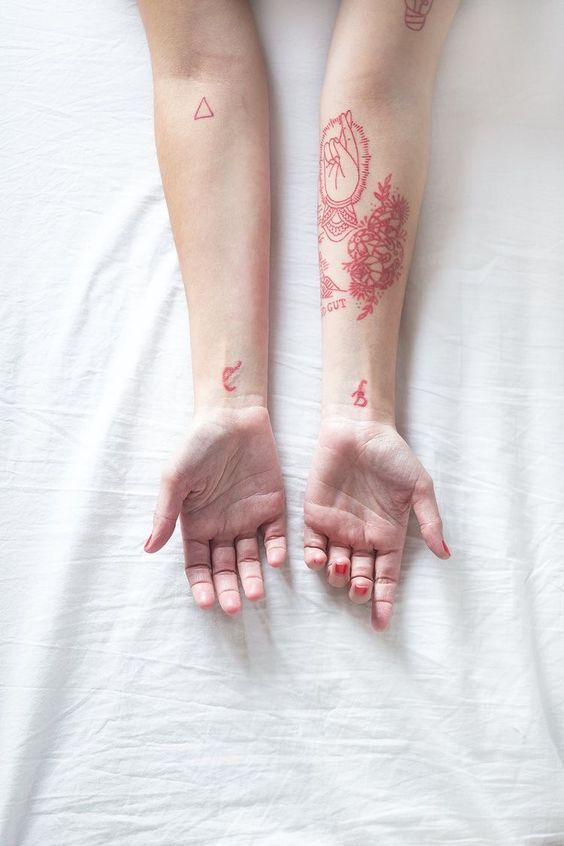 Red tattoos on both forearms