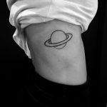 Saturn tattoo on the right rib cage