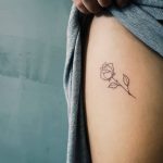 Simple rose tattoo on the thigh by artist Cholo