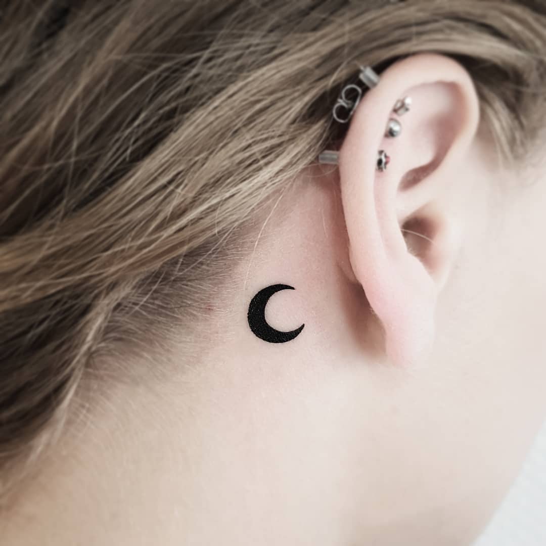 Small crescent moon behind the ear done at Mu Body Arts Studio