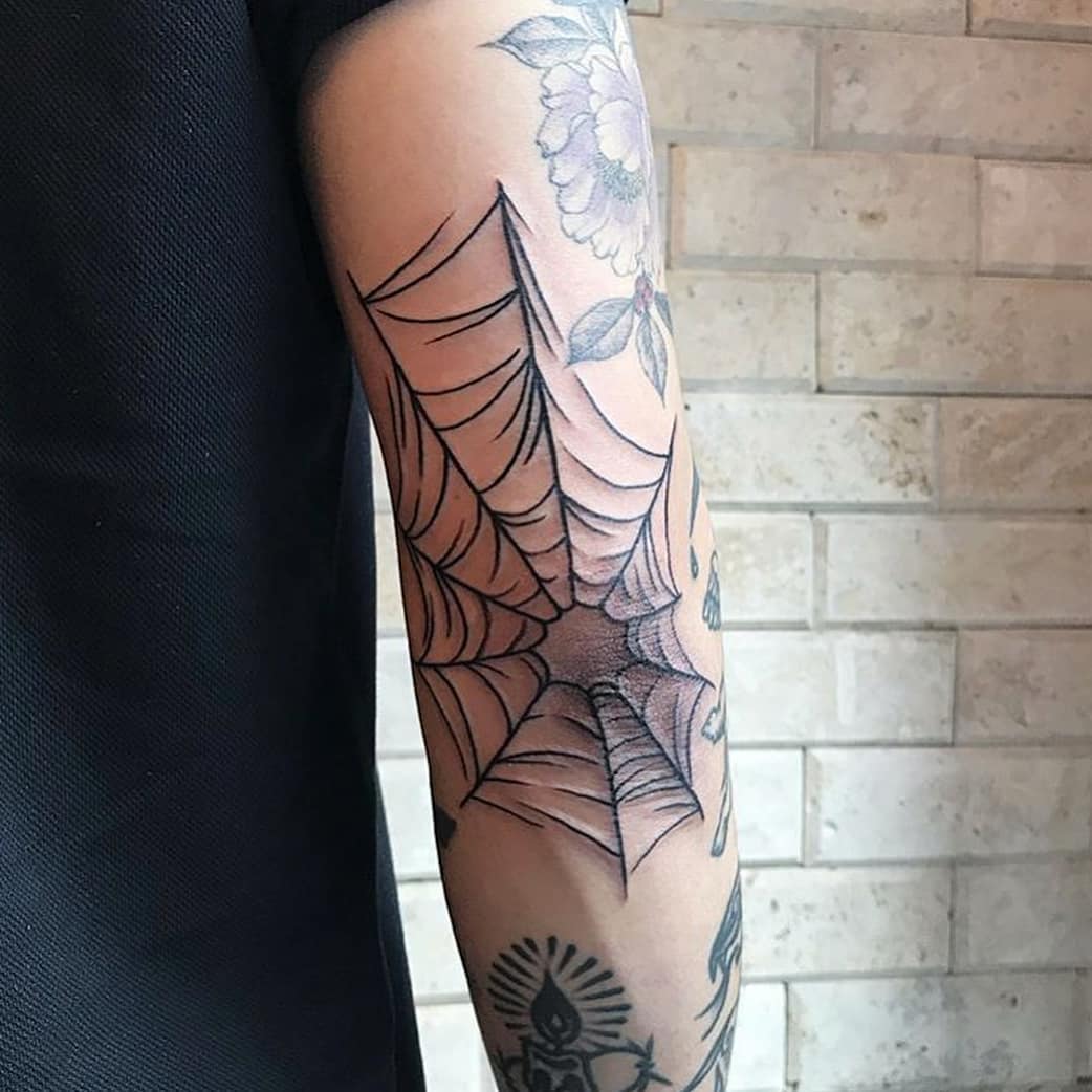 Spider web tattoo on the right elbow