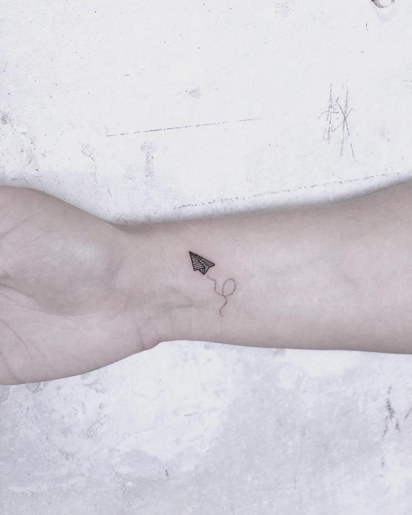 Super tiny paper plane tattoo