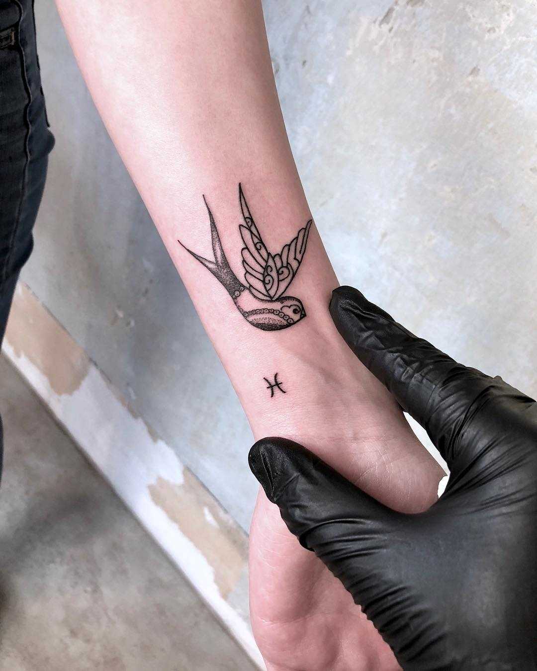 Swallow and tiny Zodiac sign tattoo