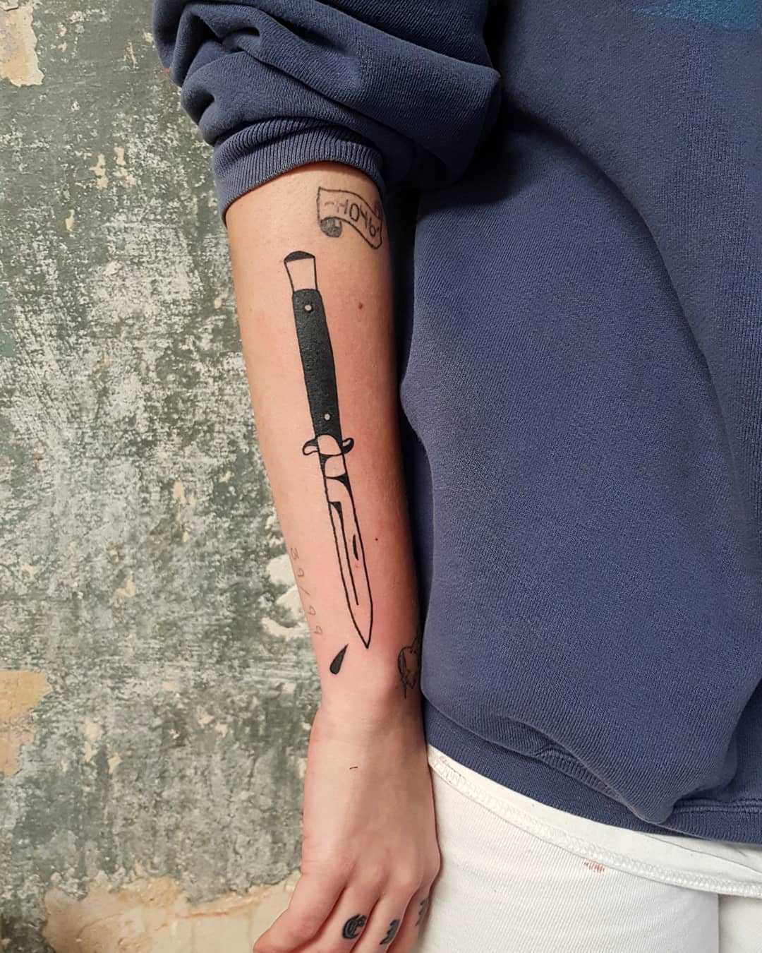 Switchblade tattoo on the right forearm 