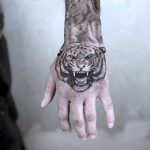 Black and grey tiger tattoo on the hand