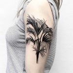 Black branches tattoo on the arm