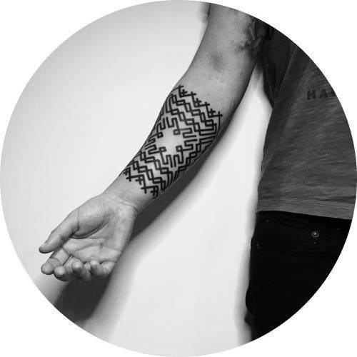 Black custom pattern tattoo on the forearm