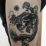 Black dragon tattoo on the thigh