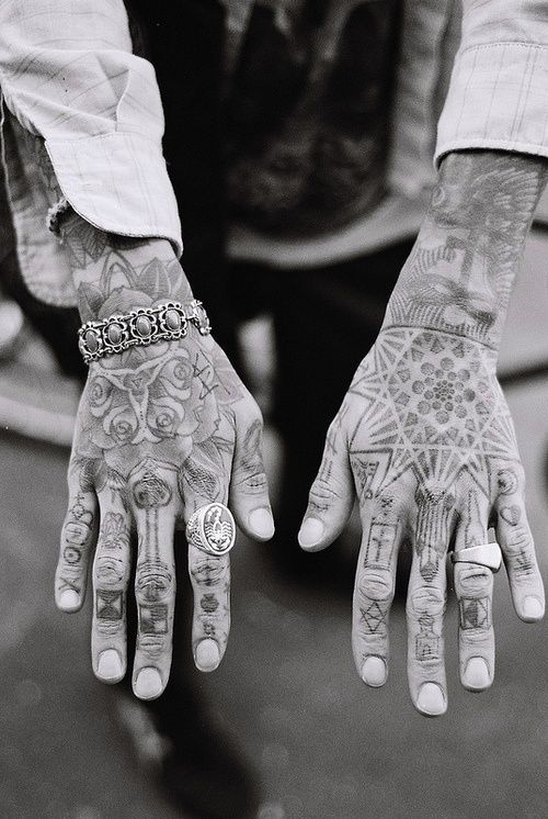 Black tattoos inked all over the hands