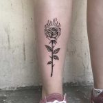 Burning rose tattoo on the shin