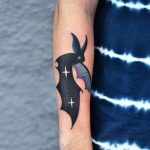 Colorful bat tattoo on the forearm