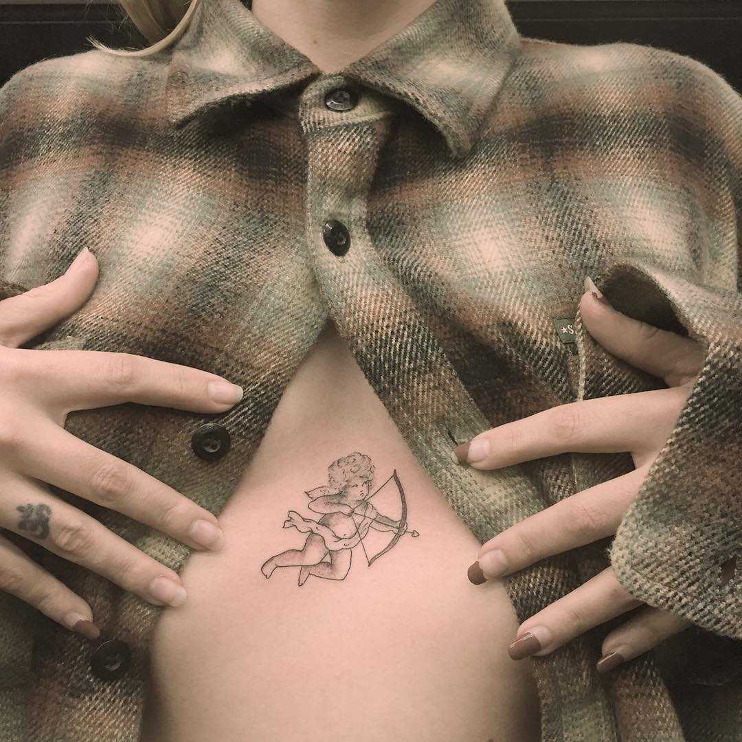 Cupid tattoo on the sternum